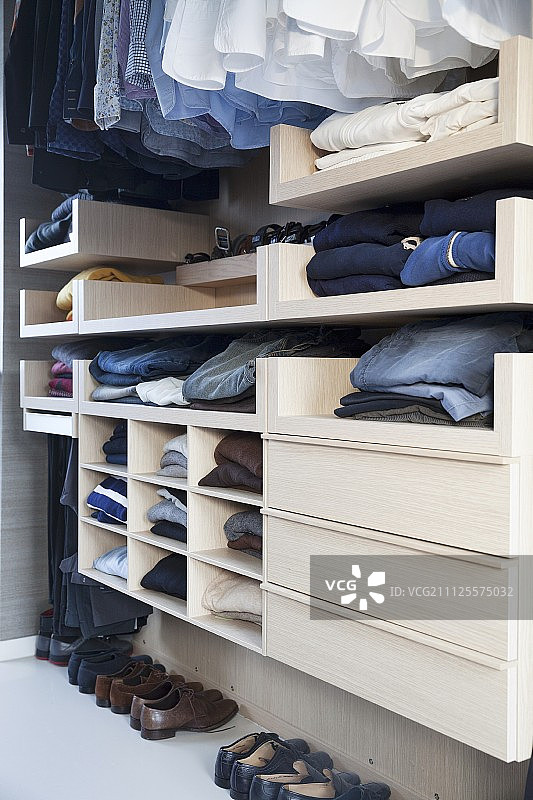 开放式衣柜，衣服挂在导轨上，梳妆室内有抽屉图片素材