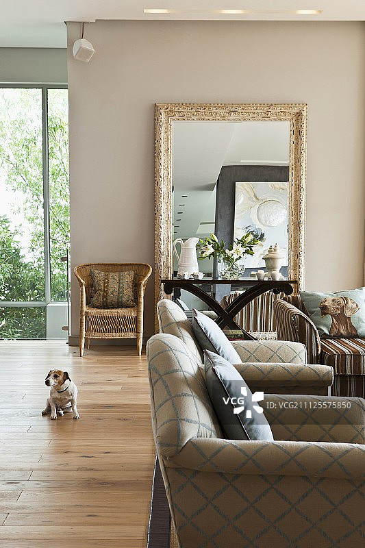 带有菱形图案扶手椅、边桌和米色墙背景上的大镜框的客厅图片素材