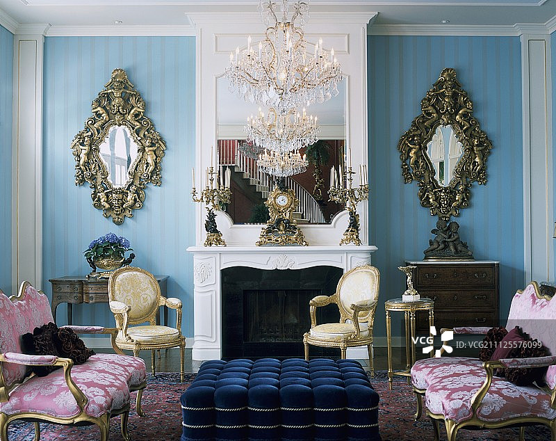 带有路易十六沙发、扶手椅和蓝色墙壁上两个镜面壁灯的洛可可风格沙龙图片素材