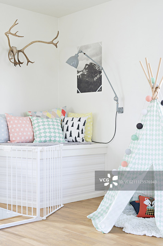 室内：粉色调的帐篷，舒适的座位区，靠垫和鹿角装饰画图片素材