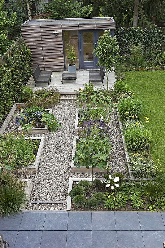 露台上现代户外家具前的几何 raised bed和碎石路图片素材