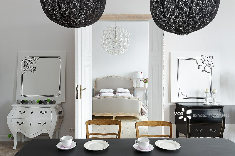从餐厅看到的古董梳妆台和通往优雅卧室的敞开式双门图片素材