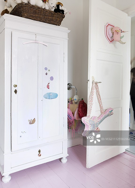 白色农舍风格衣柜与儿童房装饰，门上挂着布艺吉他图片素材