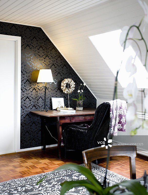 黑色壁纸搭配白色木质倾斜天花板的桌子图片素材
