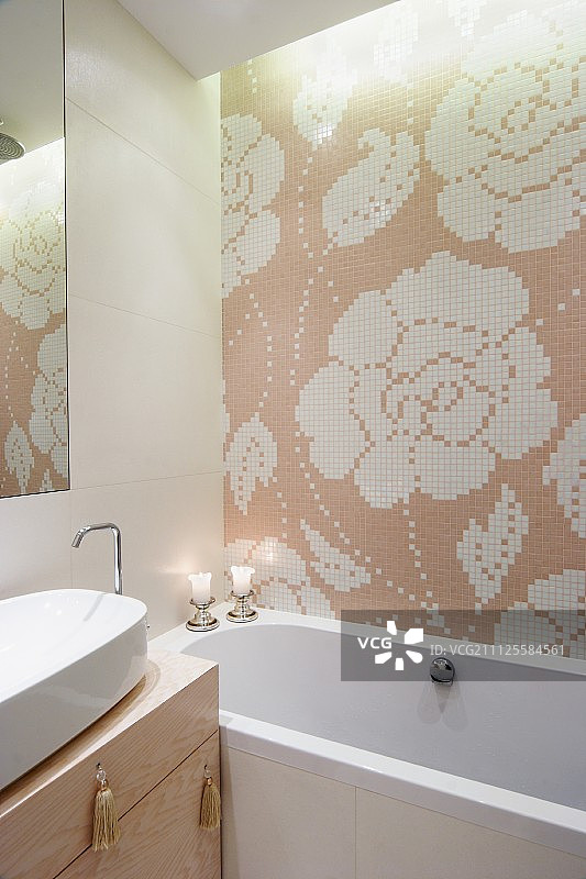 浴缸和盥洗台上的花卉瓷砖马赛克与抽屉把手上的流苏图片素材