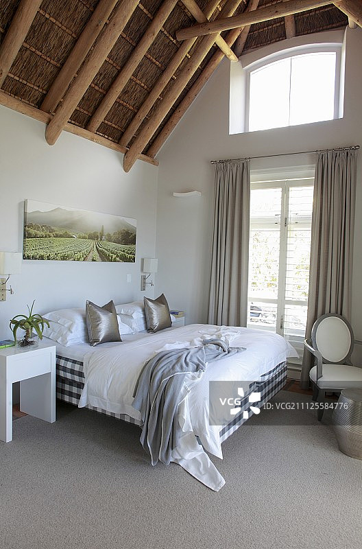 卧室落地窗帘旁带竹制屋顶的双人床图片素材