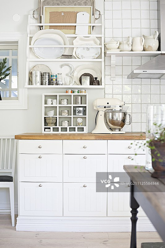 厨房台面细节：白色底座和瓷砖墙壁上的碗碟架图片素材