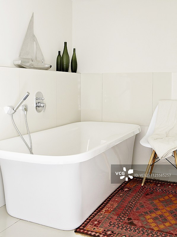 明亮浴室内的白色独立浴缸和地毯图片素材