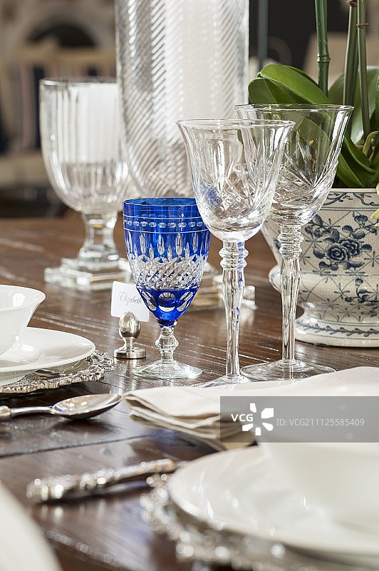 水晶杯、白色陶器和银餐具的餐桌布置细节图片素材