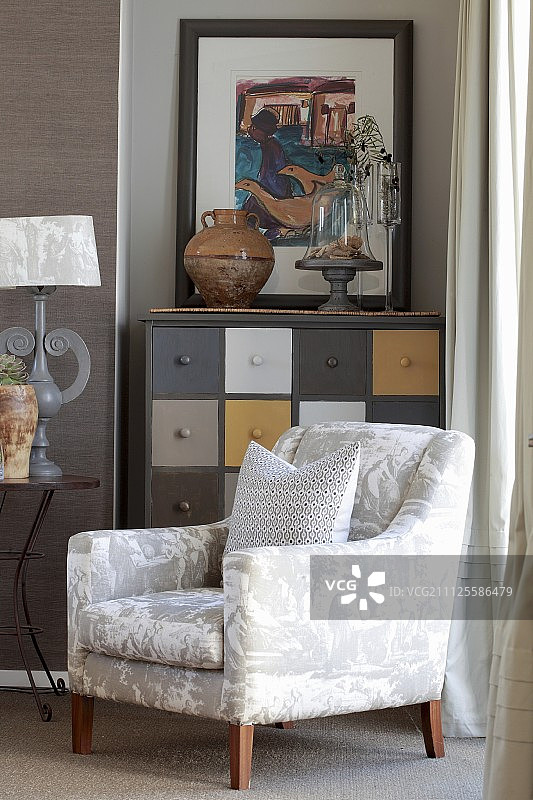 抽屉柜前带光泽的白色扶手椅图片素材