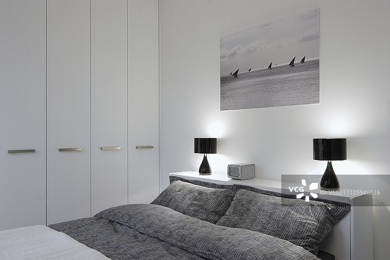 现代卧室：灰色图案床品双人床与黑色台灯图片素材