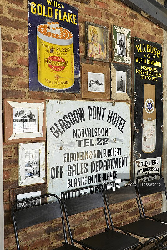 砖墙上复古金属标志下的黑色金属椅图片素材