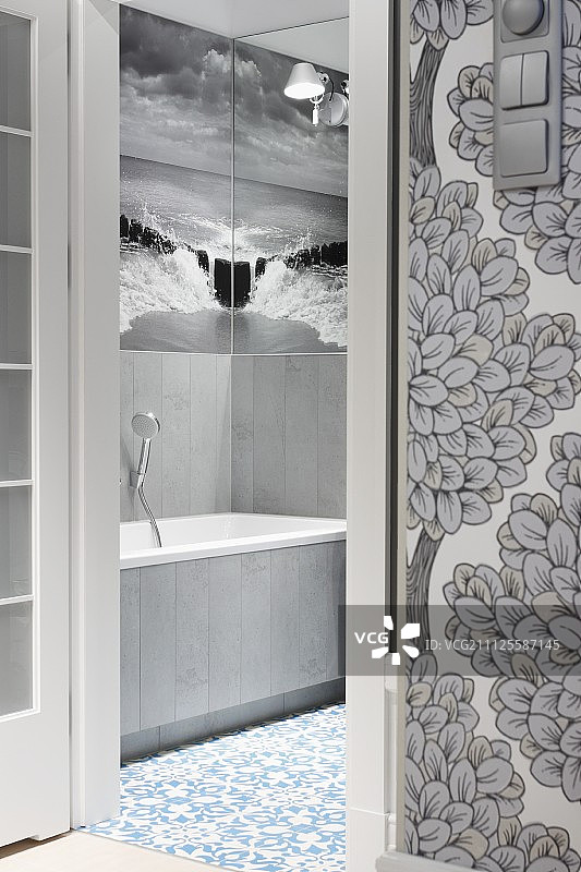透过敞开的门看浴室，黑白壁画墙纸在两面墙的镜子里映出大海和天空图片素材
