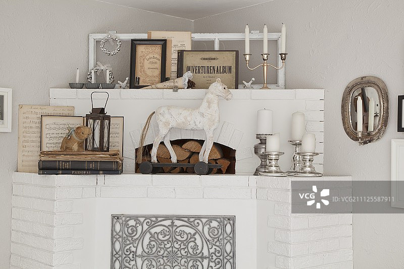 粉刷砖砌壁炉，饰有动物雕像和银烛台图片素材
