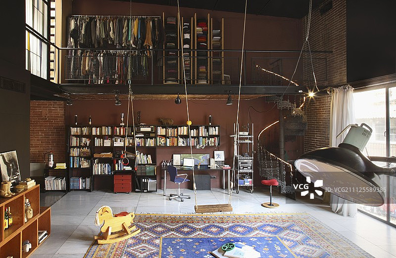 双层挑高阁楼室内设计，配有书柜和书桌，开放式衣柜位于夹层；前景为秋千和摇马图片素材