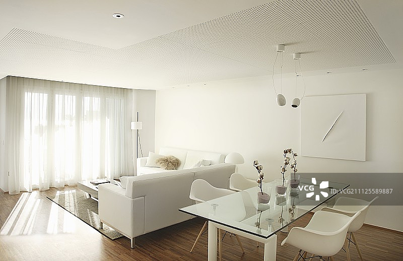 开放式室内设计：玻璃桌、经典座椅、白色沙发和落地窗帘图片素材