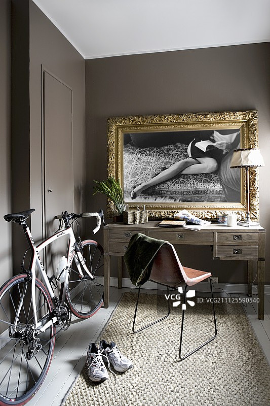 办公桌旁边的赛车自行车与镶金框黑白照片图片素材