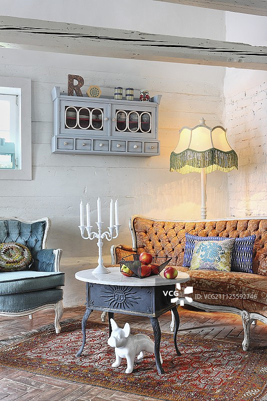 铸铁大理石面茶几、古董沙发和落地灯下的中华田园犬图片素材