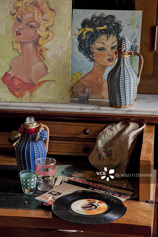 旧写字台上摆放的老唱片、玻璃杯和瓶子图片素材