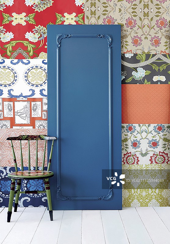 蓝色油漆门和装饰线条，背景是不同壁纸拼凑的墙壁图片素材