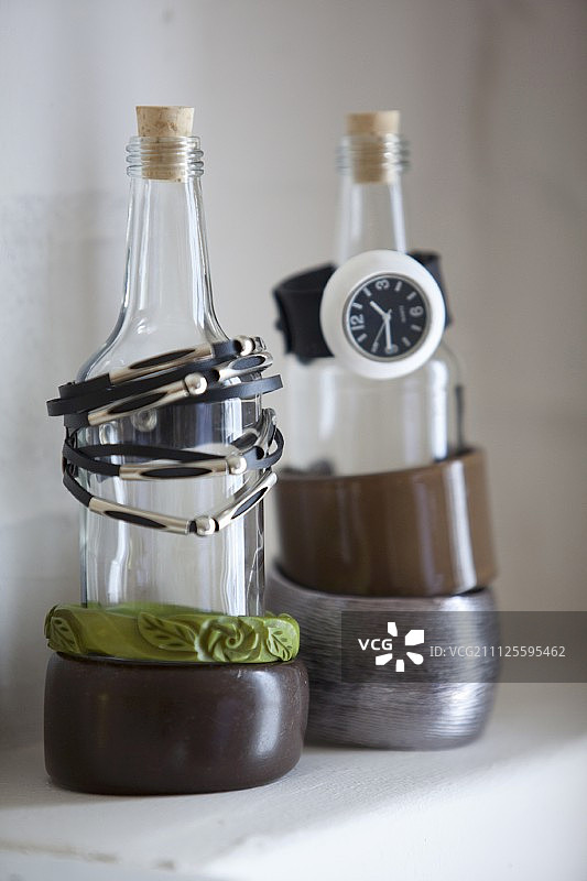 用作珠宝展示架的瓶子上的手链和手表图片素材