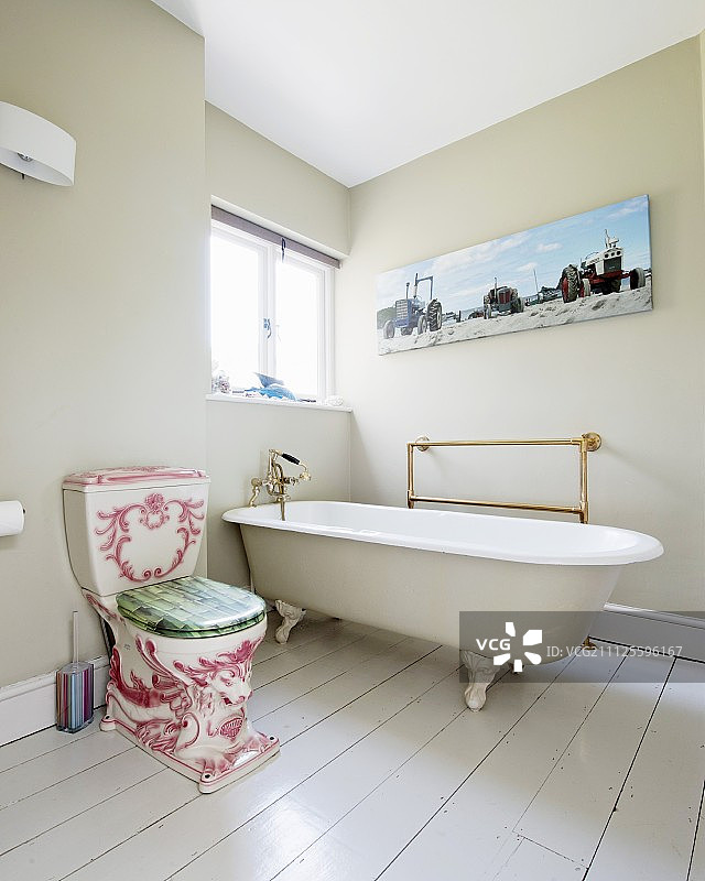 华丽的古董马桶，旁边是独立式复古浴缸，位于浴室的白色木地板上，墙壁涂成浅灰色图片素材
