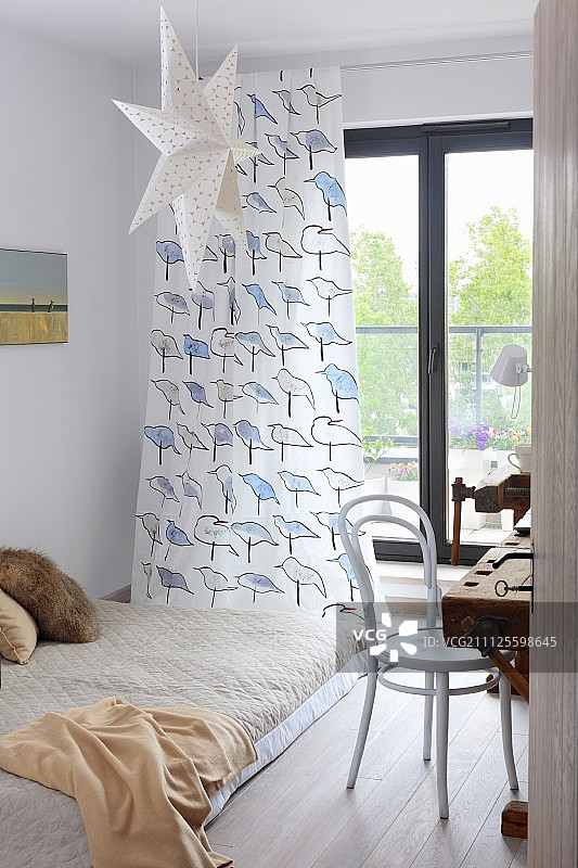 法式门上鸟纹窗帘前的被褥，纸星星和白色弯木椅图片素材
