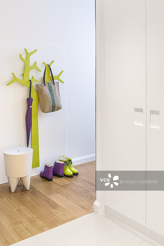 绿色风格化树状衣帽架和设计师凳子，带组合橱柜的走廊图片素材