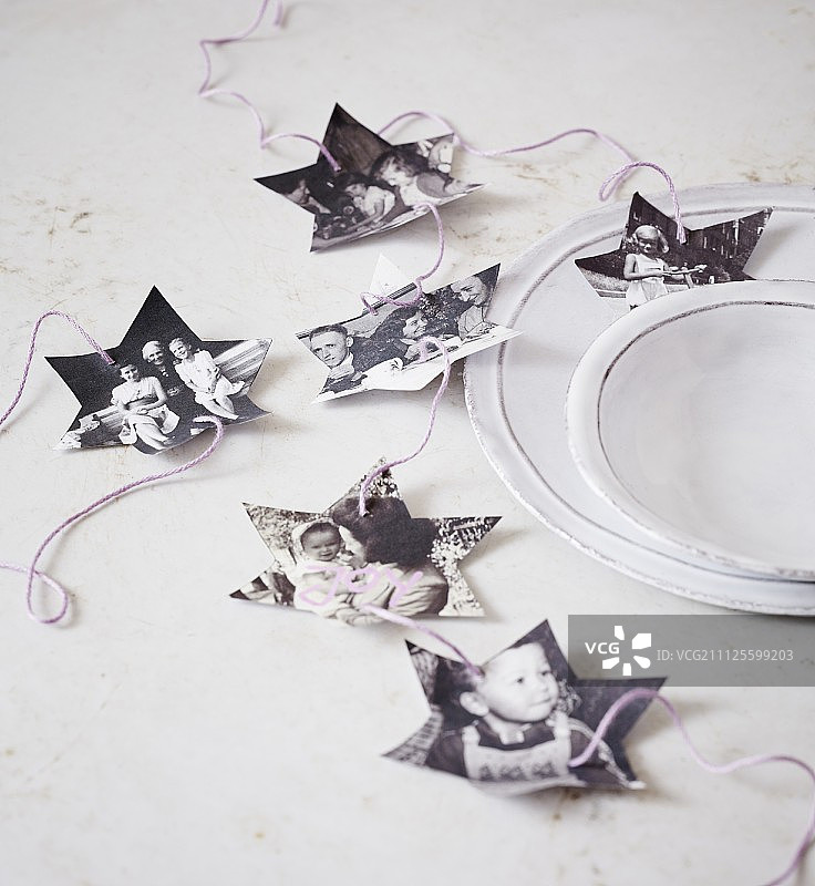 圣诞晚餐桌上复古家庭照片剪裁的星星花环图片素材