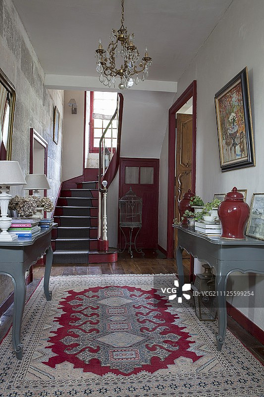 18世纪法国乡村住宅门厅的红色和灰色控制台桌图片素材