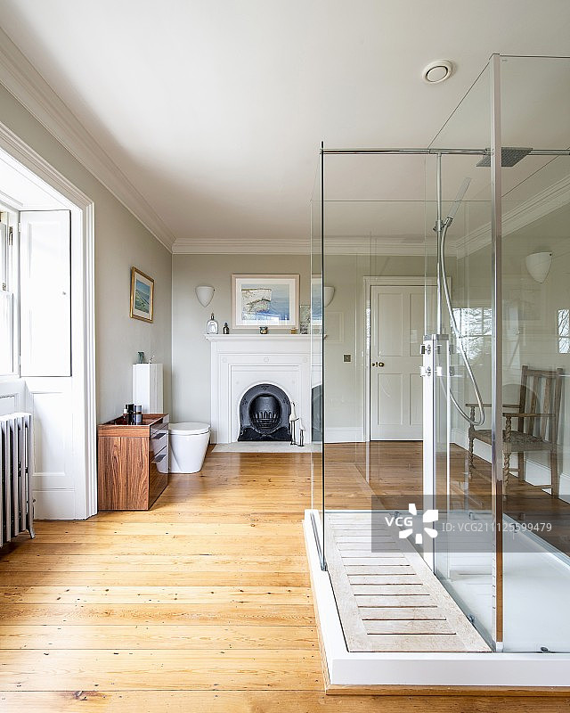 宽敞乡村浴室内的现代玻璃淋浴房图片素材