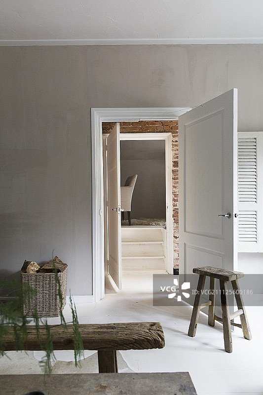 客厅门边的乡村木凳和木制脚凳，墙面为淡灰色图片素材