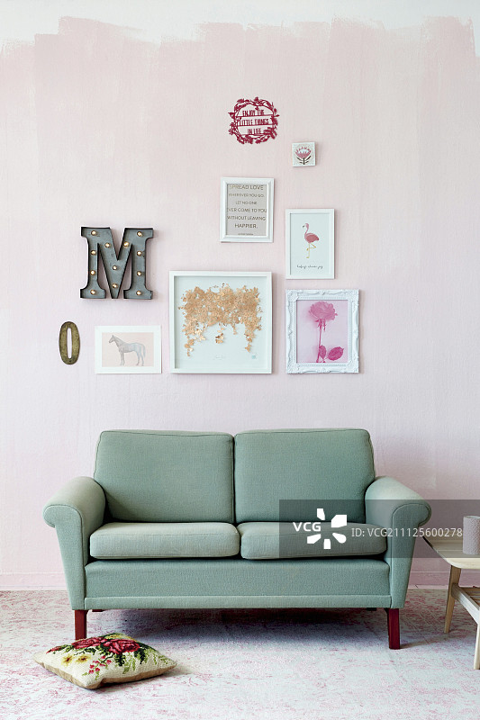 粉色墙壁和复古沙发上的手工画作图片素材