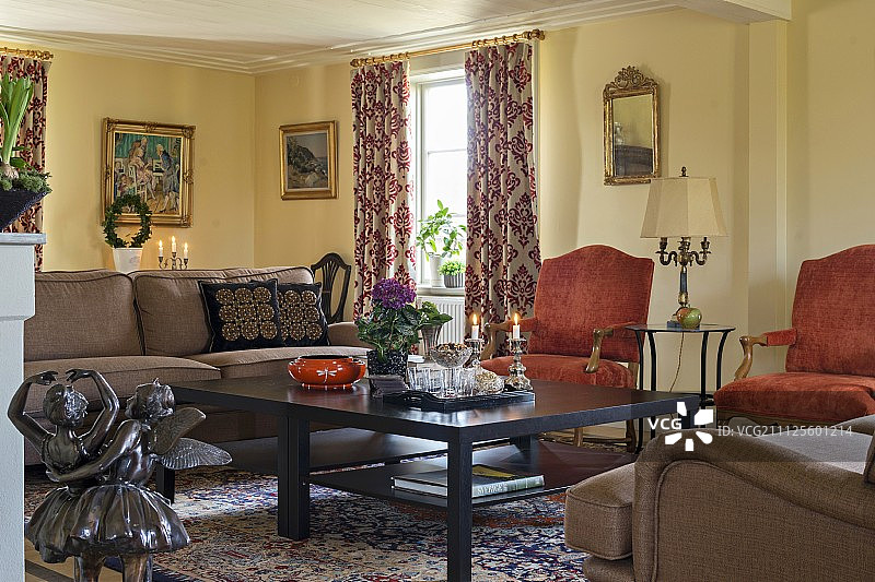 舒适客厅中黑色咖啡桌周围的各种椅子和沙发图片素材