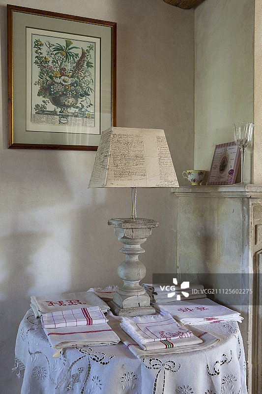 转动底座的台灯，旁边是叠好的茶巾和桌布图片素材