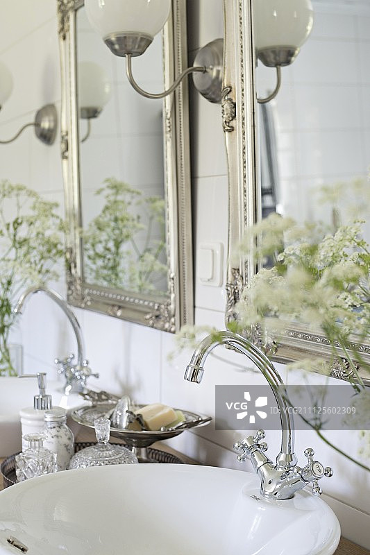 双水槽上方带有复古风格水龙头配件的两个银框镜子图片素材