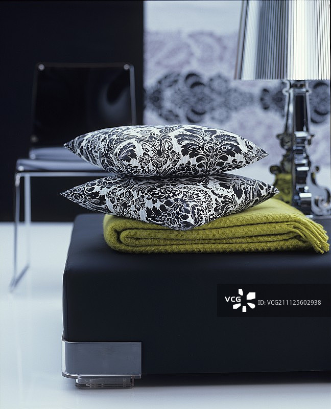 客厅里黑色蒲团上的毯子和黑白花卉靠垫图片素材