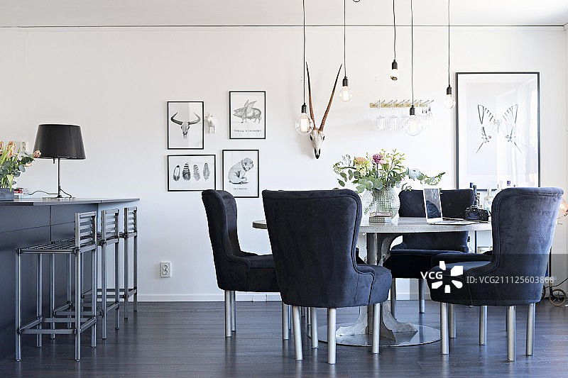 开放式起居区：灰色软垫椅、圆桌和悬挂式吊灯图片素材