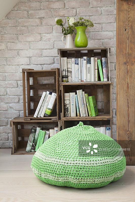 书架前的绿色钩针编织蒲团图片素材