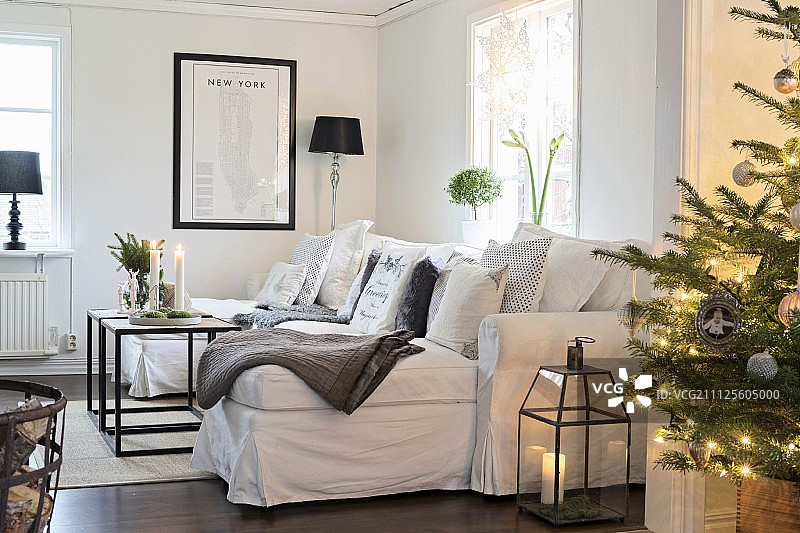 圣诞树上的装饰灯，白色沙发配多个靠垫图片素材