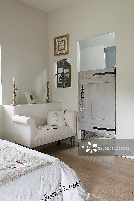 白色沙发，背景是突出的墙壁和通往浴室的乡村风格门图片素材