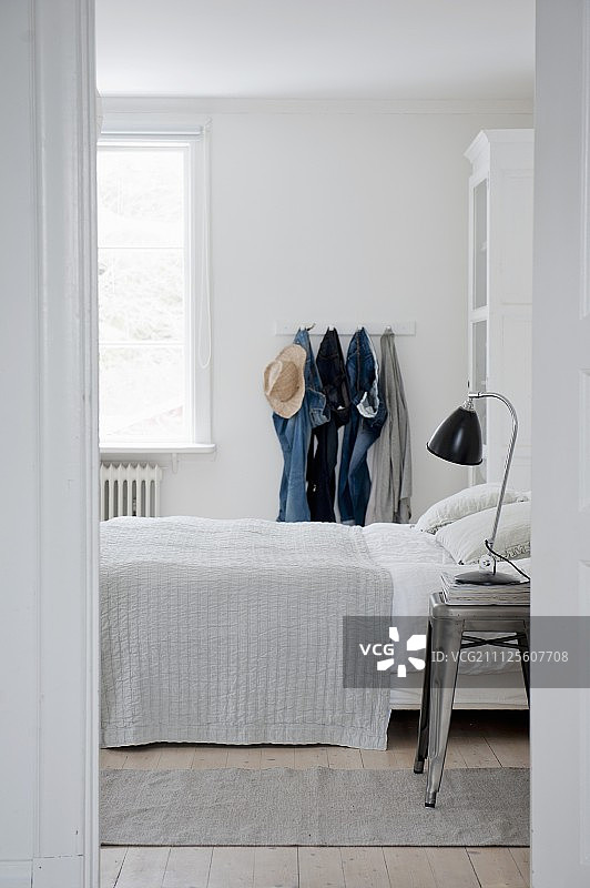 挂在白色卧室晾衣夹上的牛仔裤图片素材