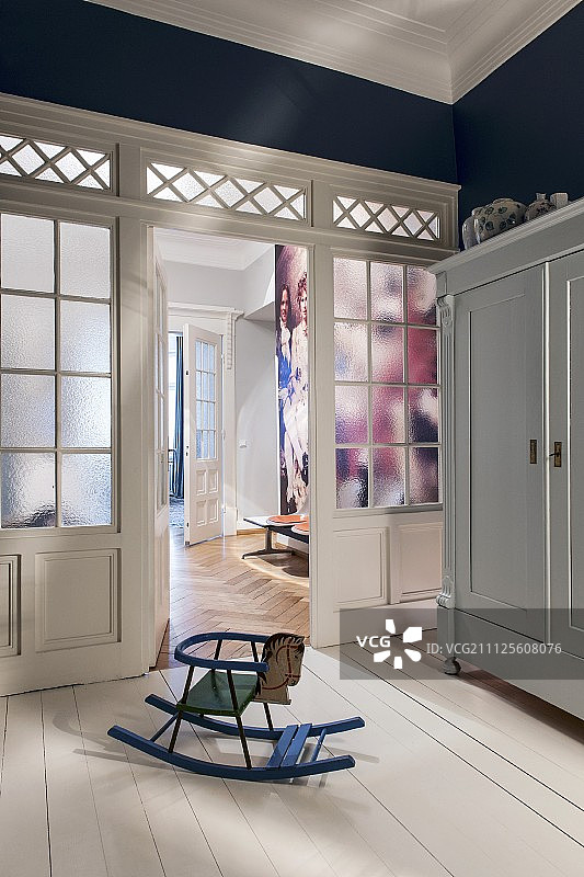 白色木地板上木质玻璃隔断前的复古摇马图片素材