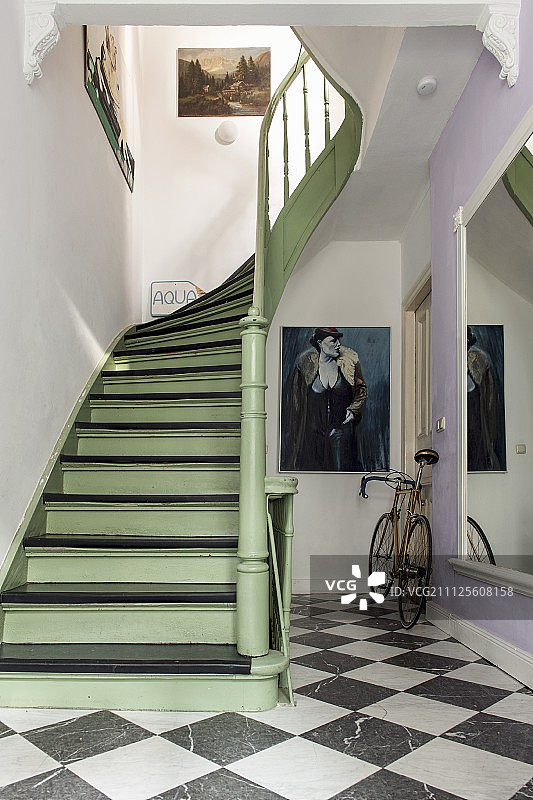 粉绿色和黑色油漆的木制楼梯，格子地板，墙边靠着赛车图片素材