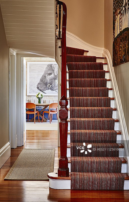 乡村走廊白色木制楼梯上的条纹地毯图片素材