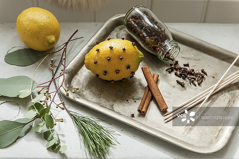 丁香柠檬、丁香开口罐和复古托盘上的肉桂棒图片素材