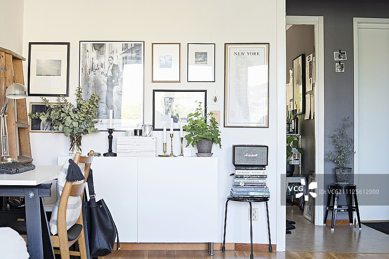 复古室内白色餐具柜上方画廊前的工作区图片素材