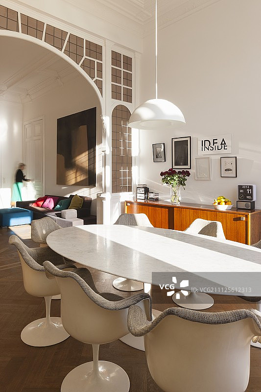 大理石台面经典椭圆桌搭配郁金香扶手椅，透过传统拱形门可欣赏休息区图片素材