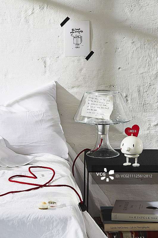 卧室装饰：灯罩和电源线在床上组成爱心图片素材