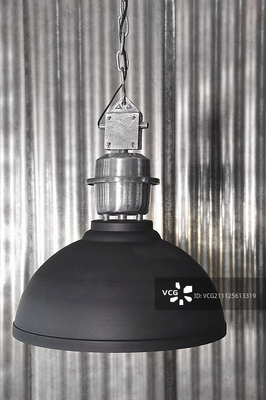 黑色工业风灯罩，背景为波纹金属墙图片素材